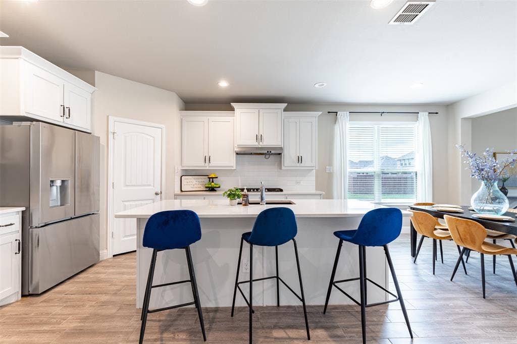 405 Rosie Court, Argyle, TX 76226 Spacious kitchen featuring a large island with bar seating, farmhouse sink and walk-in pantry, perfect for gathering and entertaining.