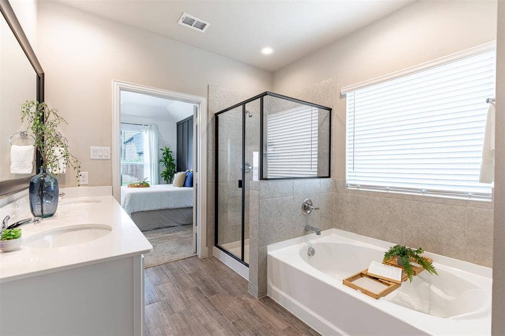 405 Rosie Court, Argyle, TX 76226 Primary bathroom featuring a relaxing garden tub, separate shower, and large privacy window that fills the space with natural light while maintaining privacy.