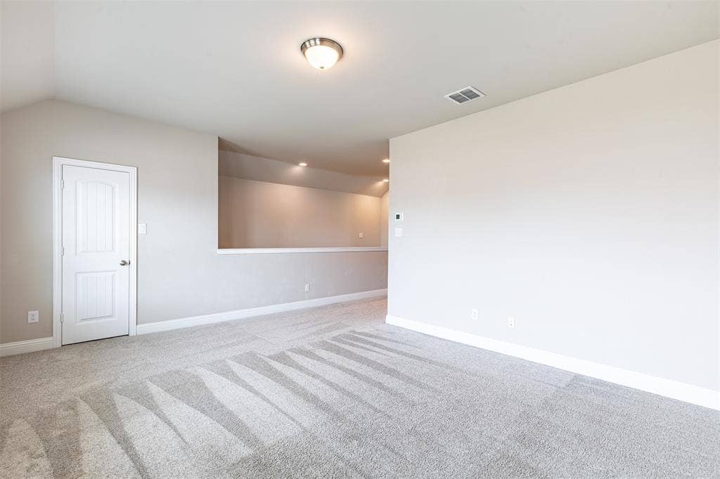 405 Rosie Court, Argyle, TX 76226 Large second-floor game room with a spacious walk-in closet, providing abundant storage and flexible space for a media room, playroom, home gym, or entertainment area.