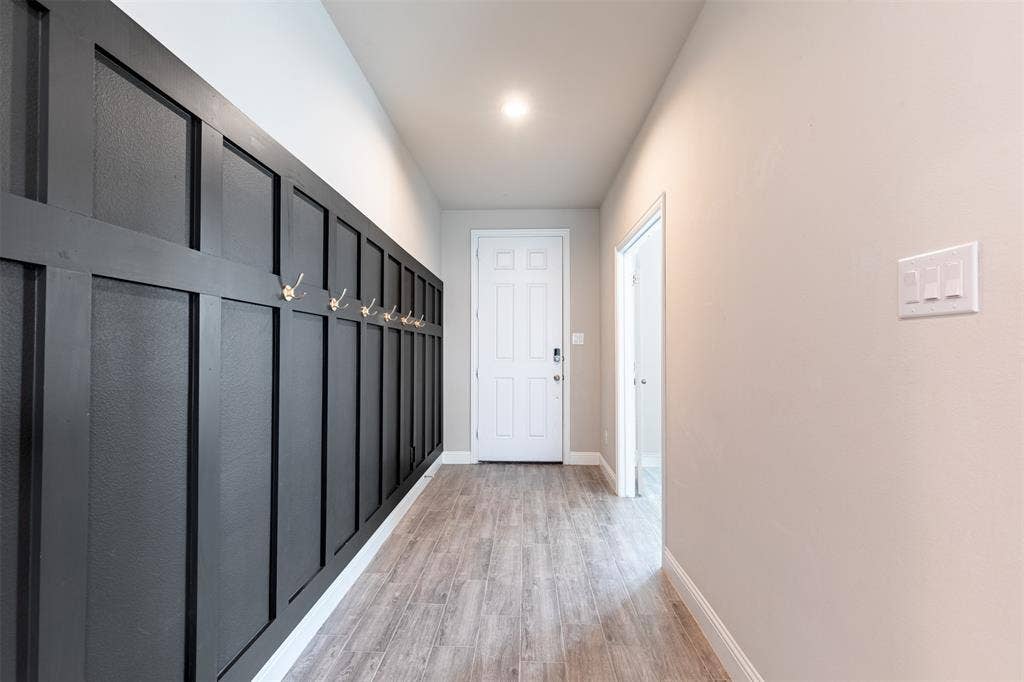 405 Rosie Court, Argyle, TX 76226 Welcoming entryway featuring a charming board-and-batten accent wall with convenient hooks, adding character and functional storage to the home.