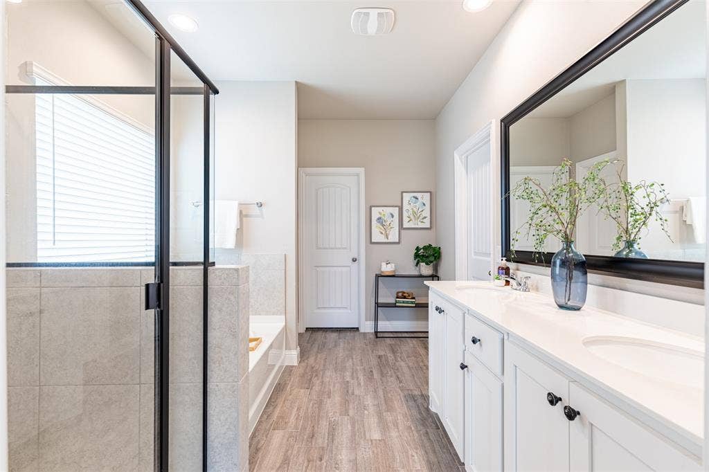405 Rosie Court, Argyle, TX 76226 Spacious primary bathroom featuring a double vanity, garden tub, separate shower, two large walk-in closets, and ample storage.