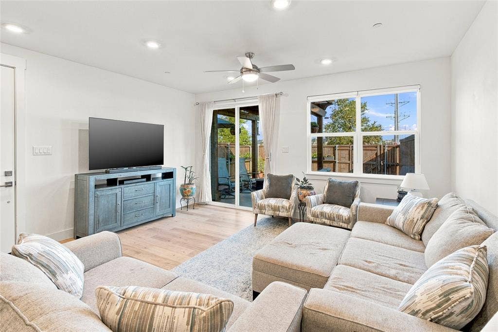 Open-concept living space featuring wood-finish flooring, recessed lighting, a ceiling fan, and sliding glass doors to the exterior
