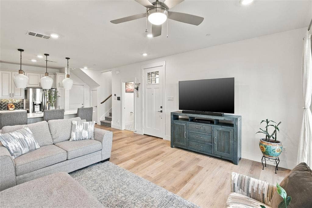 Open-concept interior featuring light wood-finish flooring, recessed lighting, a brushed-nickel ceiling fan, and pendant lighting over a kitchen island