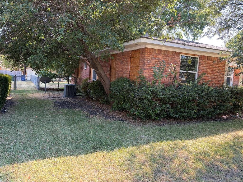 Brick exterior, mature trees, manicured lawn, established shrubbery, chain-link fencing
