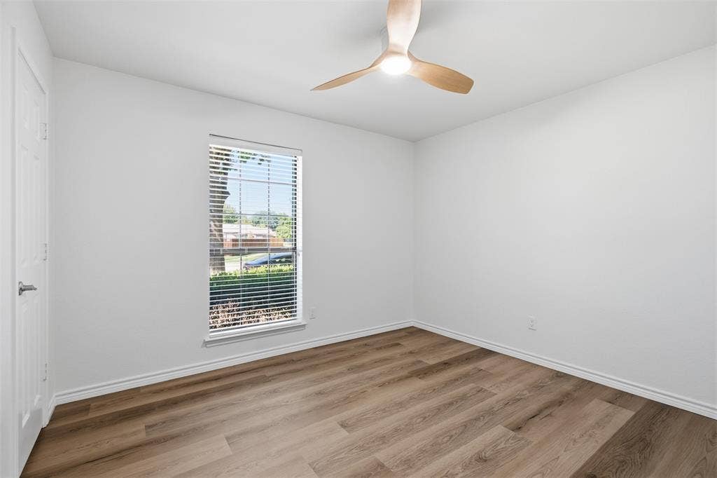 661 Thompson Drive, Coppell, TX 75019 Expansive room featuring wood-finish flooring, a contemporary ceiling fan with integrated lighting, and a window equipped with blinds
