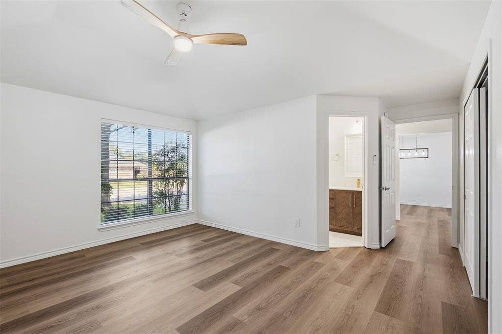 661 Thompson Drive, Coppell, TX 75019 Wood-finish flooring throughout, bright white walls, and a window with blinds provide a neutral canvas