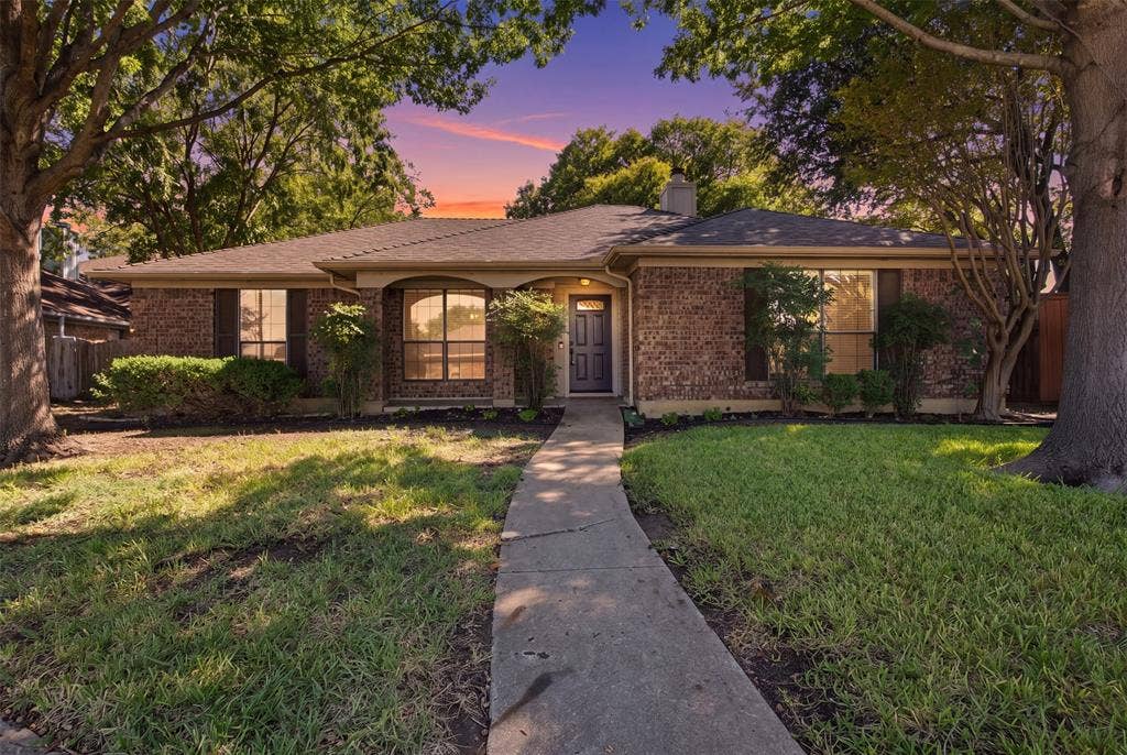 661 Thompson Drive, Coppell, TX 75019 Brick exterior with dark shutters, covered entry, and a concrete pathway