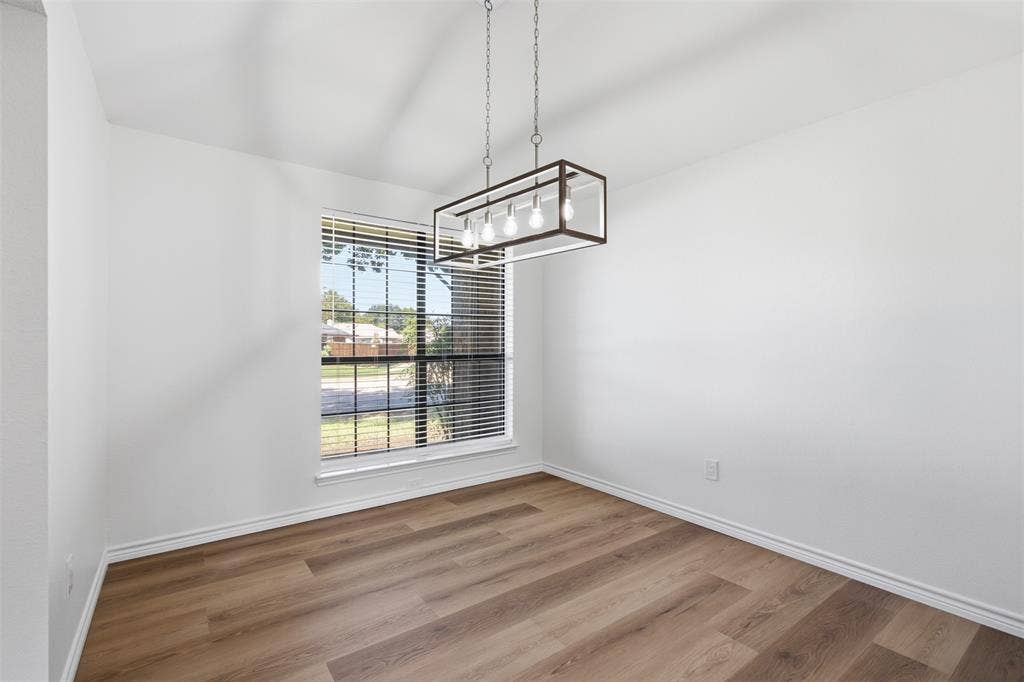 661 Thompson Drive, Coppell, TX 75019 Recessed window with horizontal blinds, wood-finish flooring, and a modern rectangular chandelier