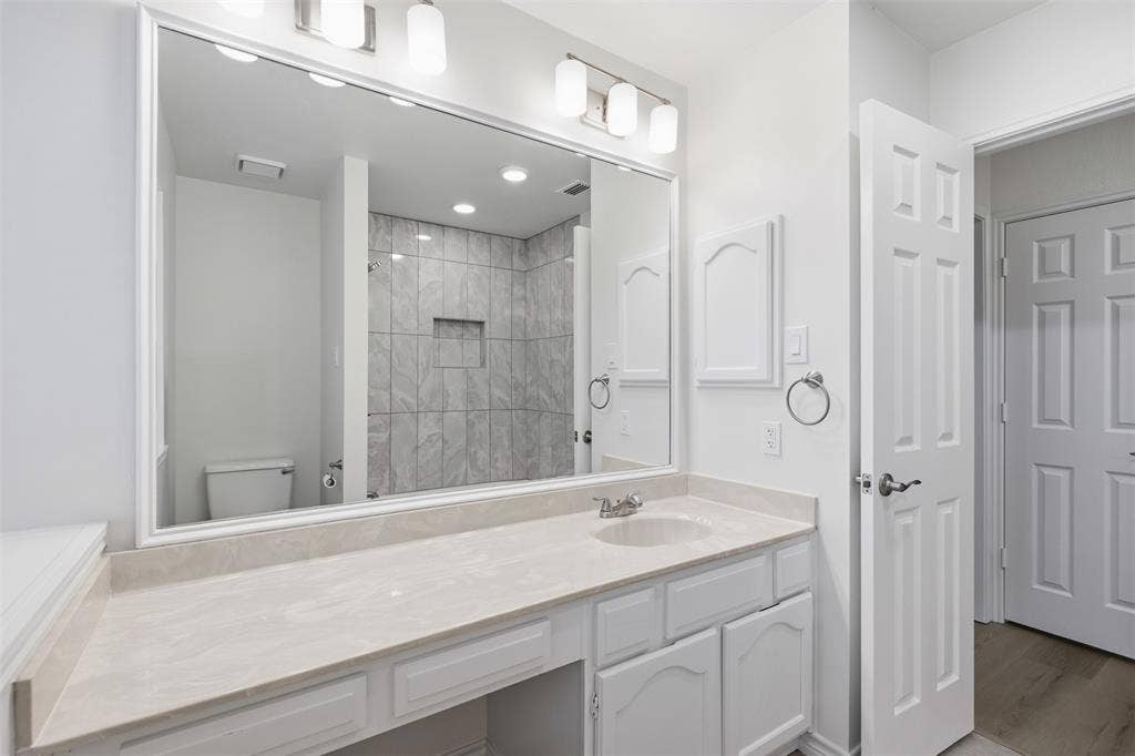 661 Thompson Drive, Coppell, TX 75019 Expansive vanity featuring a single basin, light-toned countertop, and white cabinetry