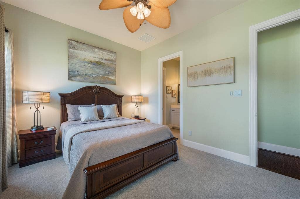 Neutral wall coloring, wall-to-wall carpeting, and a ceiling fan with integrated lighting