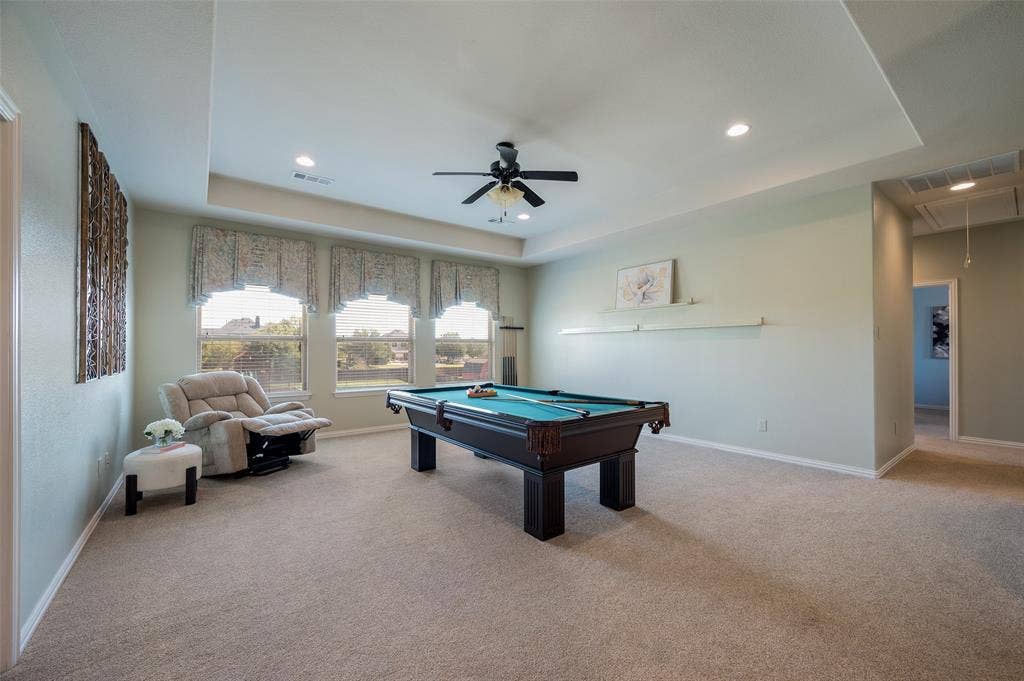 Tray ceiling featuring recessed lighting and a central ceiling fan, expansive carpeting, and oversized windows
