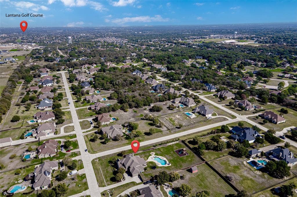Aerial perspective of the residential property featuring a backyard swimming pool, expansive grounds, and proximity to Lantana Golf Course