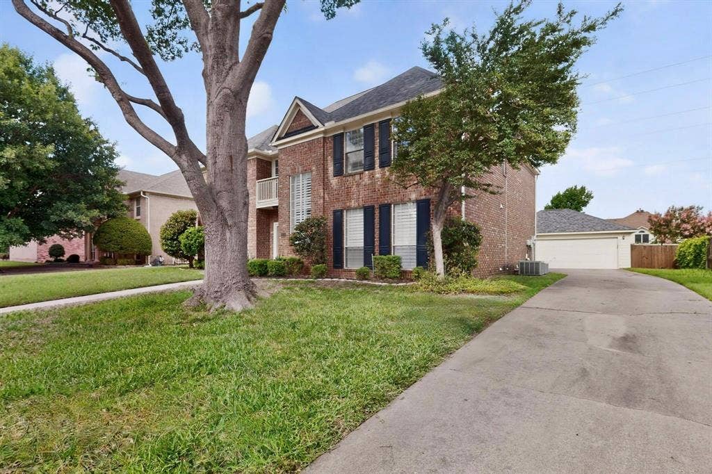 Brick exterior residence with a concrete driveway, two-story design, and prominent front-facing gables