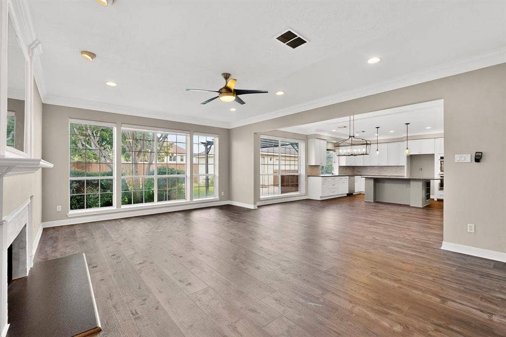 Open-concept living space featuring wood-finish flooring, recessed lighting, and a decorative ceiling fan