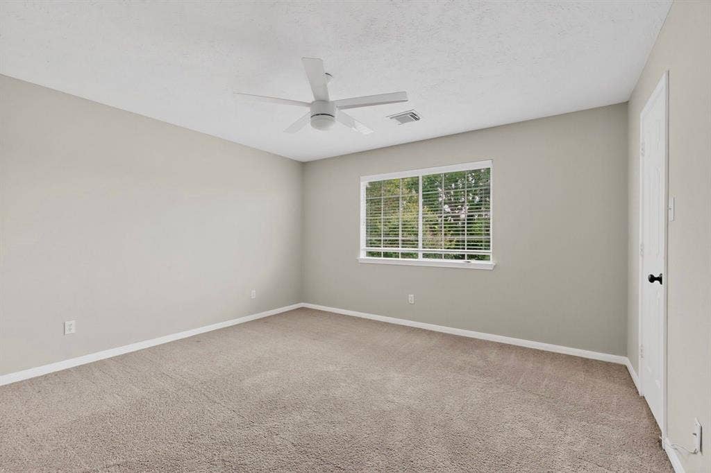 Wall-to-wall carpeting, neutral wall finishes, window with blinds, and ceiling fan