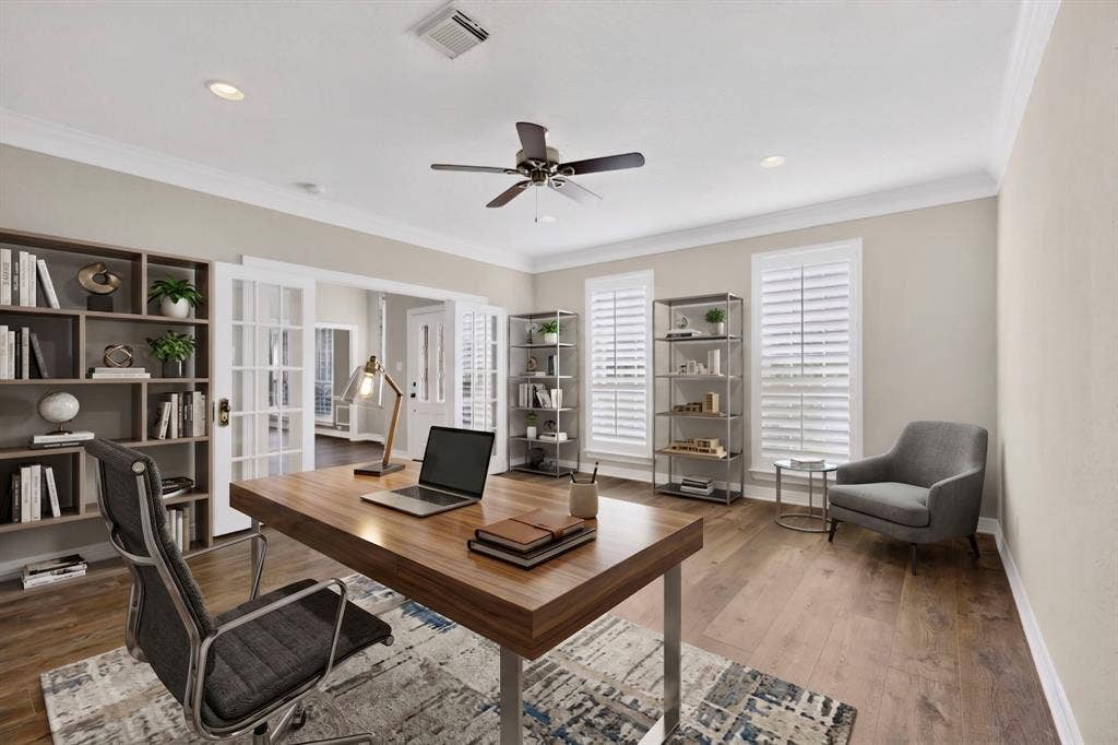 Wood-finish flooring, two large windows with plantation shutters, French doors, recessed lighting, and a ceiling fan