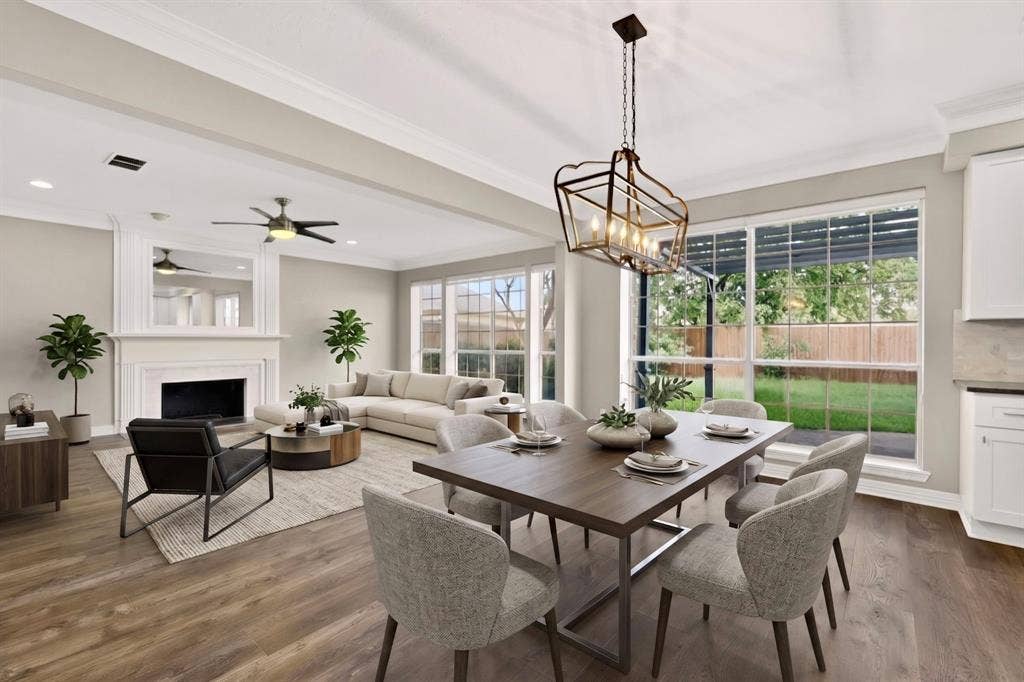 Open-concept living space featuring wood-finish flooring, a decorative fireplace with an ornate mantel, and a ceiling fan