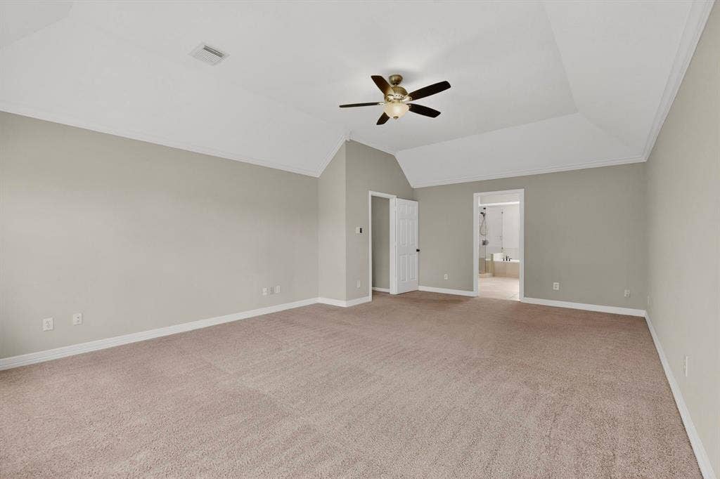 Spacious room with tray ceiling, neutral wall tones, and plush carpet