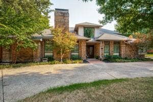 5212 Mustang Trail, Plano, TX 75093 Brick exterior with a prominent chimney, large windows, and an asphalt driveway