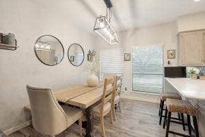 5212 Mustang Trail, Plano, TX 75093 Vaulted ceilings with a linear chandelier, wood-finish flooring, and a large window with blinds