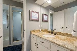 5212 Mustang Trail, Plano, TX 75093 Vanity with a polished stone countertop, undermount sink, and dark bronze-finish fixtures