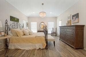 5212 Mustang Trail, Plano, TX 75093 Spacious room with wood-finish flooring, vaulted ceiling, recessed lighting, and a crystal chandelier
