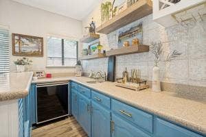 5212 Mustang Trail, Plano, TX 75093 Light blue cabinetry with gold-tone hardware, wood-finish flooring, undermount sink, and a built-in beverage refrigerator