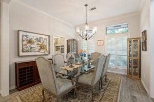 5212 Mustang Trail, Plano, TX 75093 Crown molding accents, wood-finish flooring, and a decorative chandelier
