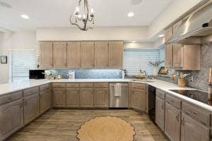 5212 Mustang Trail, Plano, TX 75093 U-shaped kitchen featuring light wood-finish cabinetry, light countertops, wood-finish flooring, recessed lighting, and a chandelier