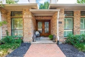 5212 Mustang Trail, Plano, TX 75093 Brick exterior with a covered entry, double wood-finish front doors with decorative glass, and a brick paver walkway