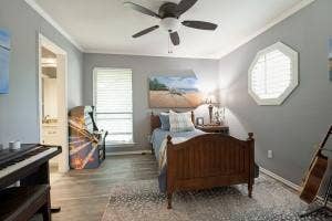 5212 Mustang Trail, Plano, TX 75093 Wood-finish flooring, ceiling fan, octagonal window with plantation shutters, window with blinds, and white trim accents