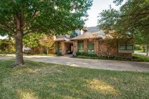 5212 Mustang Trail, Plano, TX 75093 Brick exterior with multiple window styles, concrete driveway, and mature landscaping