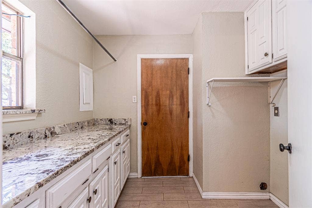 8808 Sylvan Court, Fort Worth, TX 76120 Extensive countertop space, white cabinetry, built-in upper cabinets, and tile flooring