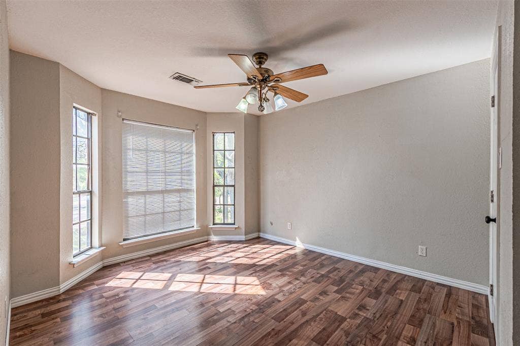 8808 Sylvan Court, Fort Worth, TX 76120 Wood-finish flooring throughout, ceiling fan with integrated lighting, and multiple windows with roller shades