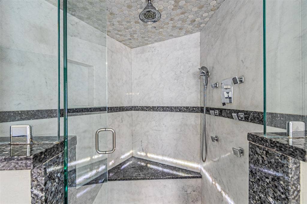 8808 Sylvan Court, Fort Worth, TX 76120 Glass-enclosed shower featuring a tiled ceiling, a built-in corner bench, and a built-in shower niche