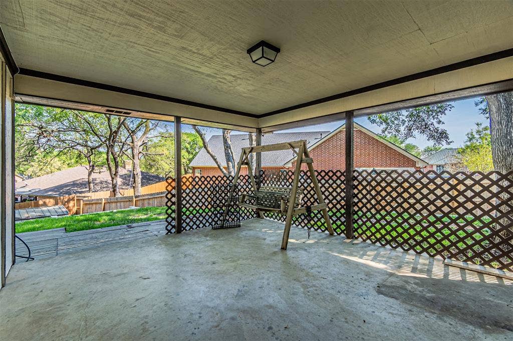 8808 Sylvan Court, Fort Worth, TX 76120 Expansive covered patio with concrete flooring, framed openings, and lattice screening