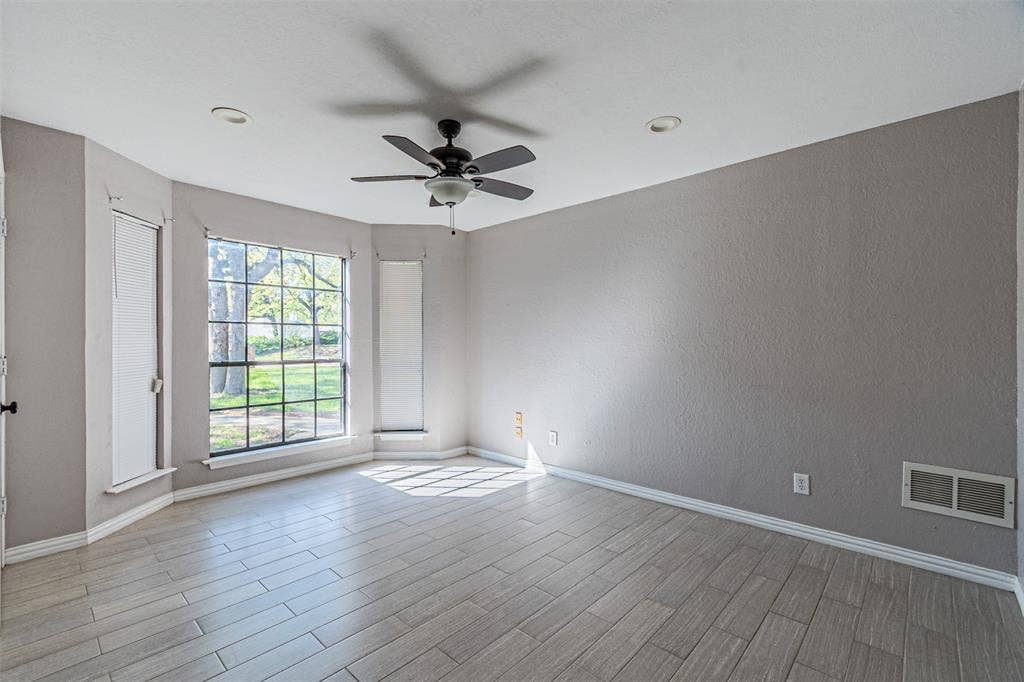 8808 Sylvan Court, Fort Worth, TX 76120 Wood-finish plank flooring, ceiling fan with integrated lighting, recessed ceiling lighting, and a bay window