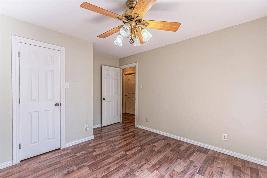 8808 Sylvan Court, Fort Worth, TX 76120 Wood-finish flooring, ceiling fan with integrated lighting, white trim, and white paneled doors