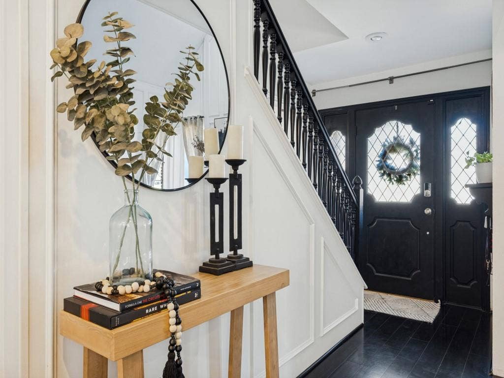 5730 Winding Woods Trail, Dallas, TX 75227 Foyer entry featuring black-painted solid wood door with diamond-pattern glass sidelights, dark-stained wood-finish flooring, and wall panel molding