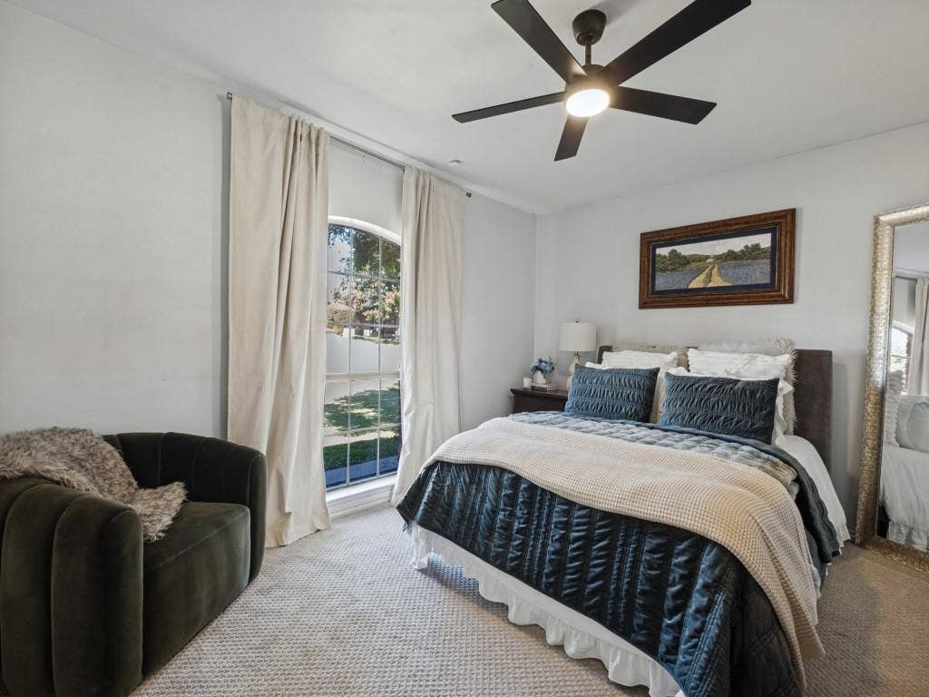 5730 Winding Woods Trail, Dallas, TX 75227 Arched window, neutral wall-to-wall carpeting, and a modern black multi-blade ceiling fan with integrated lighting
