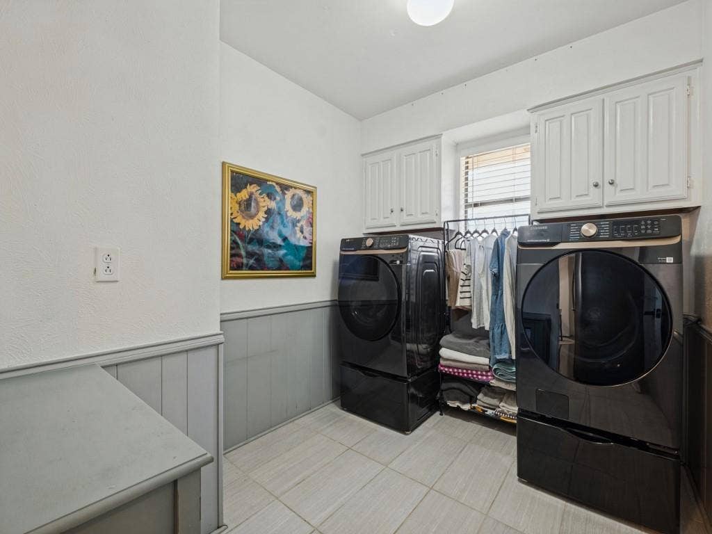 5730 Winding Woods Trail, Dallas, TX 75227 Laundry space featuring tile flooring, white upper wall cabinetry, and gray lower wall wainscoting