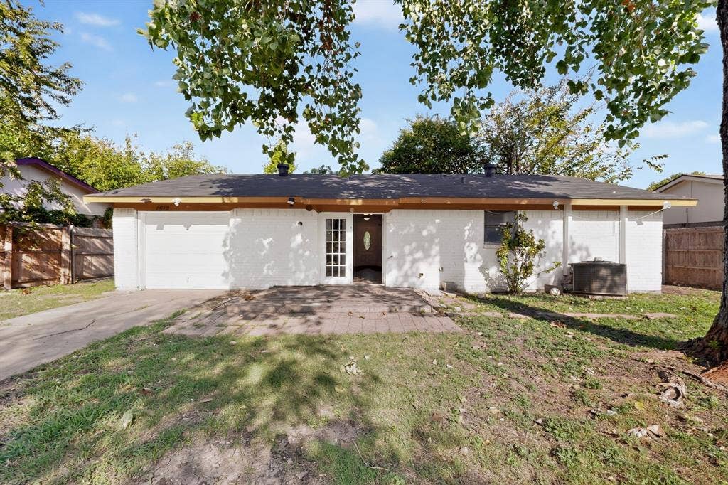 1512 Bay Shore Drive, Garland, TX 75040 Single-story residence featuring white painted brick exterior, attached garage, paver patio, and multi-pane entry door
