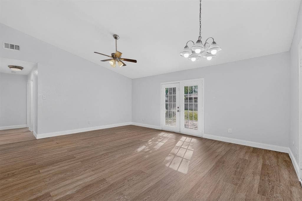 1512 Bay Shore Drive, Garland, TX 75040 Vaulted ceilings, wood-finish flooring, multi-light chandelier, ceiling fan, and French doors