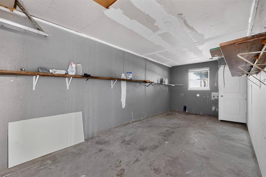 1512 Bay Shore Drive, Garland, TX 75040 Garage featuring a single-hung window and wall-mounted shelving