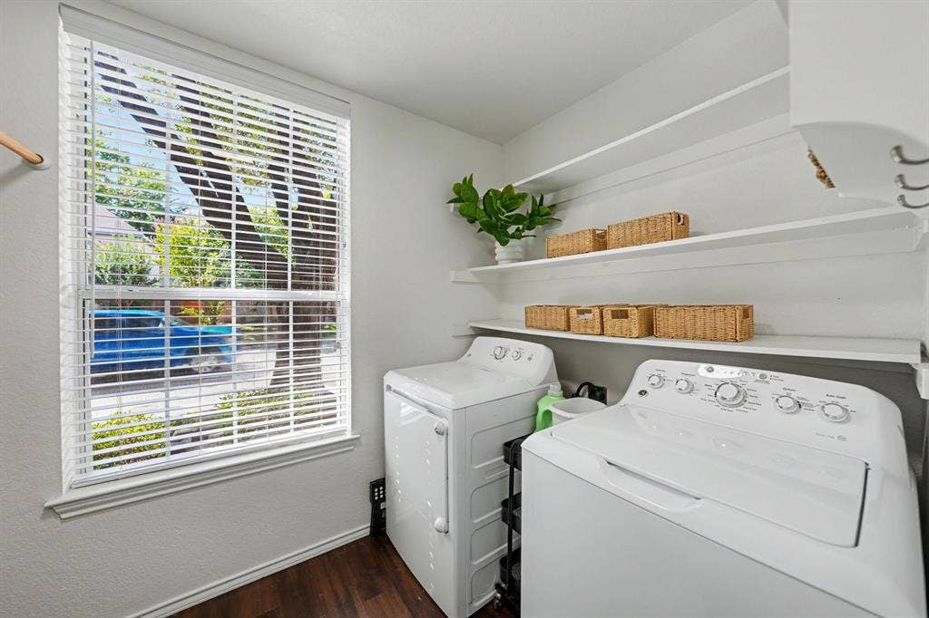 Window with white blinds, wood-finish flooring, and built-in shelving
