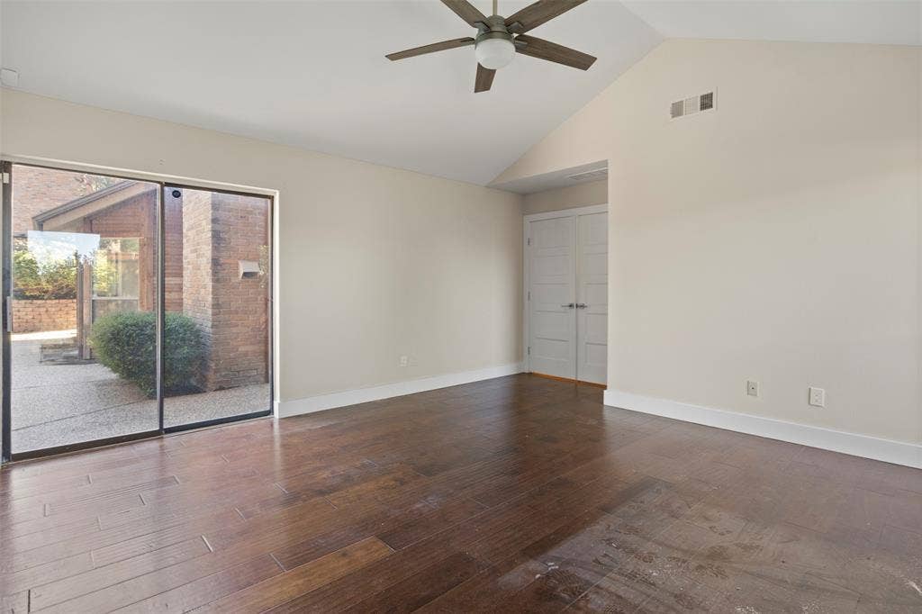 Vaulted ceiling with a ceiling fan, wood-finish flooring, and sliding glass doors