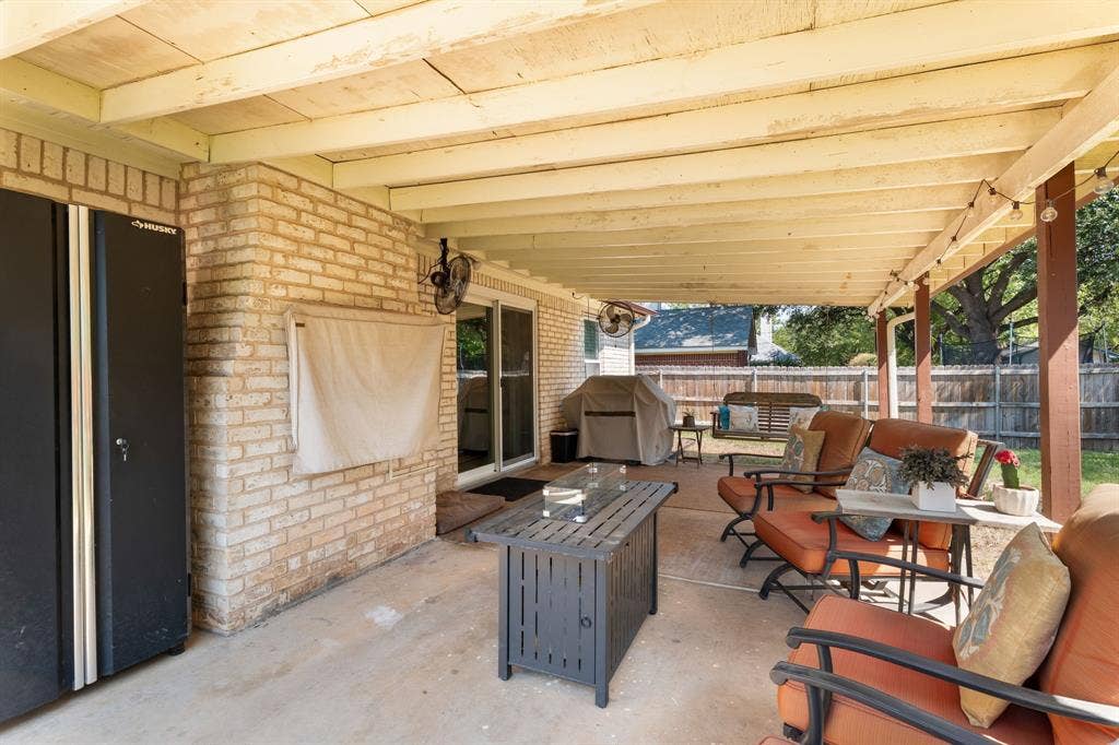 10712 Apache Drive, Waco, TX 76712 Covered patio with a concrete slab, exposed wood beam ceiling, and brick exterior wall