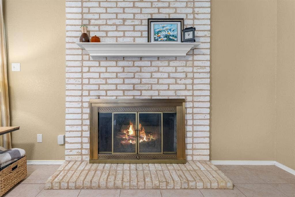 10712 Apache Drive, Waco, TX 76712 Brick fireplace with a painted finish and a brass-framed firebox