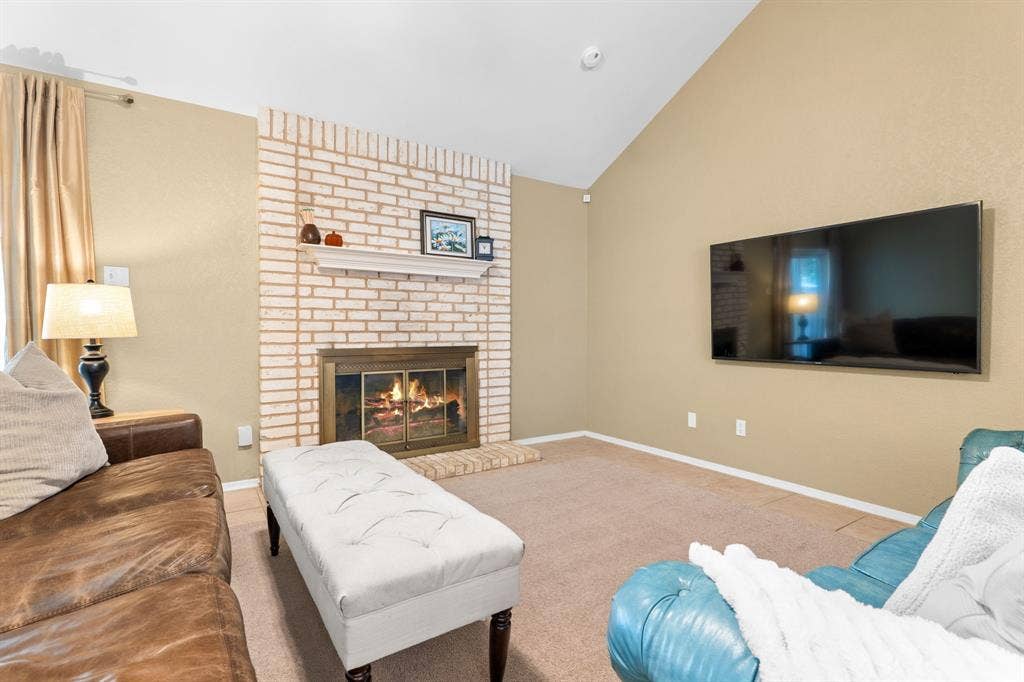10712 Apache Drive, Waco, TX 76712 Vaulted ceiling with an exposed beam, brick fireplace, and built-in mantel
