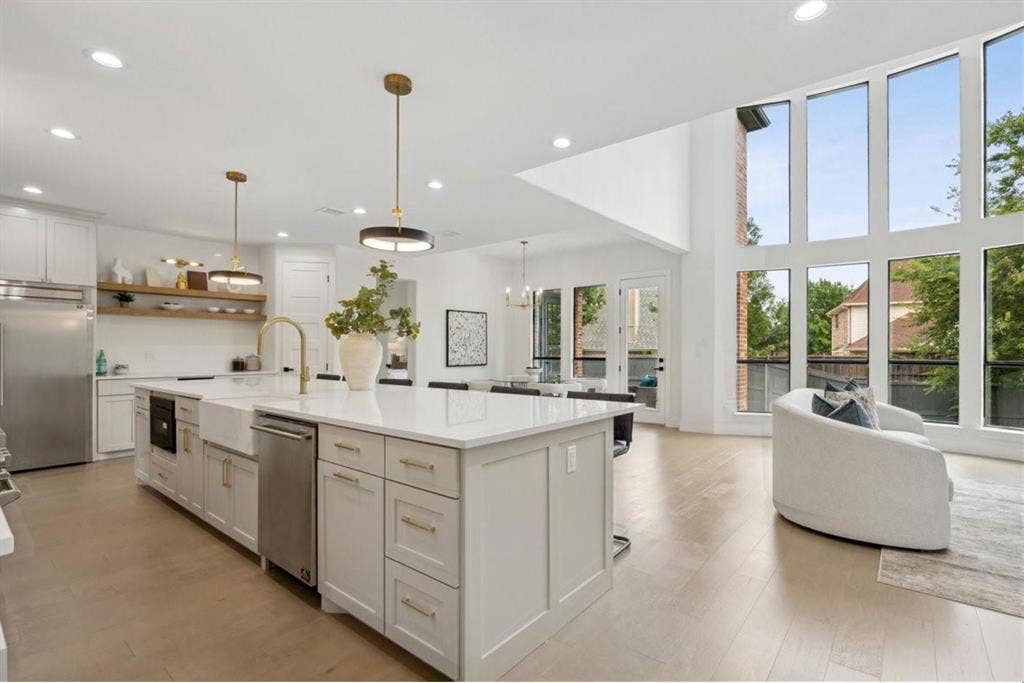 1750 Greenwood Court, Prosper, TX 75078 Gourmet kitchen featuring a large island with a farmhouse sink, stainless steel appliances, and white cabinetry